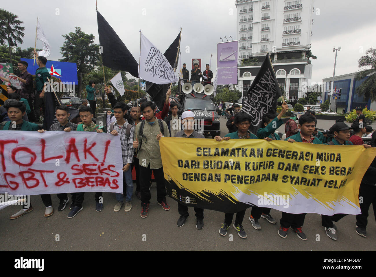 Bogor, West Java, Indonesien. 13 Feb, 2019. Die Demonstranten werden gesehen, die Transparente und Fahnen während des Protestes. Eine Reihe von demonstranten gesehen wurden Plakate und Banner, wenn Sie den Valentinstag feiern abgelehnt (14. Februar) bei Tugu Kujang, Bogor, Sie laden Jugendliche religiöse Fragen mehr als in den Valentinstag feiern teilnehmen zu studieren. Credit: Adriana Adinandra/SOPA Images/ZUMA Draht/Alamy leben Nachrichten Stockfoto