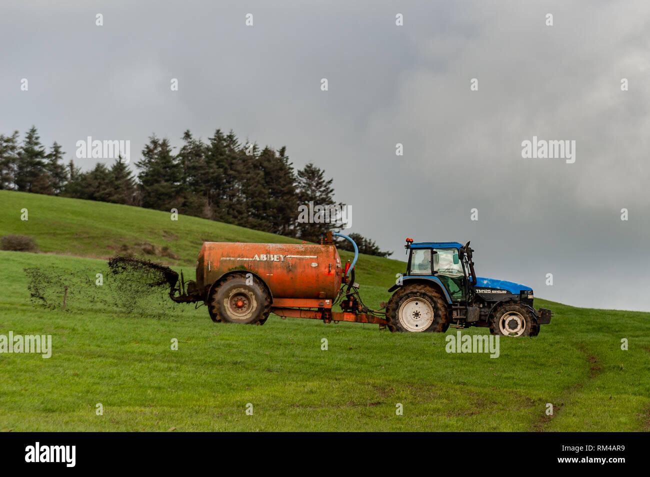 Landwirt spreads Gülle auf seiner Farm in Drinagh, West Cork, Irland mit kopieren. Stockfoto