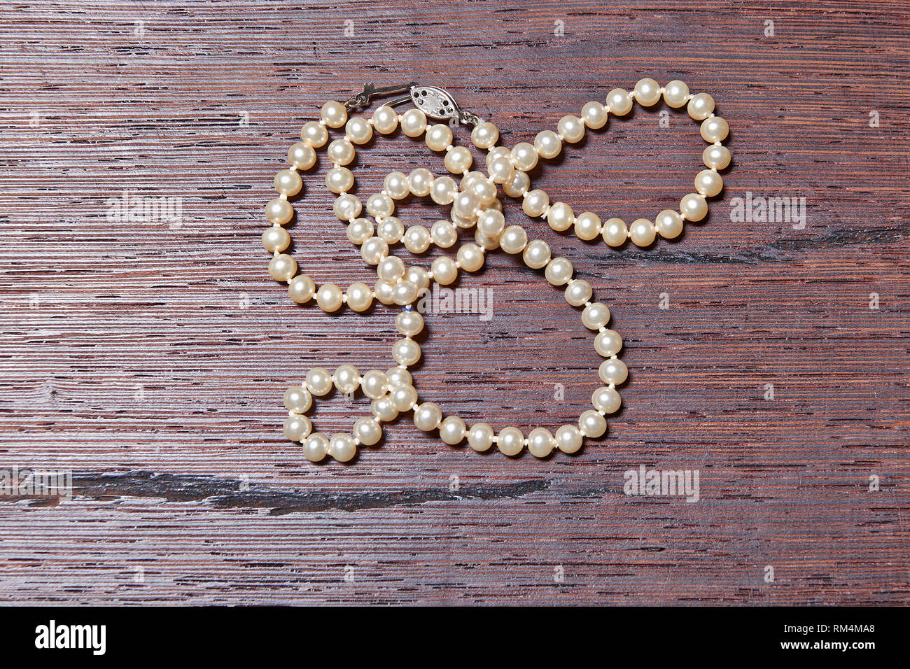Wunderschöne Perlenkette auf strukturierte Holzblock Stockfoto