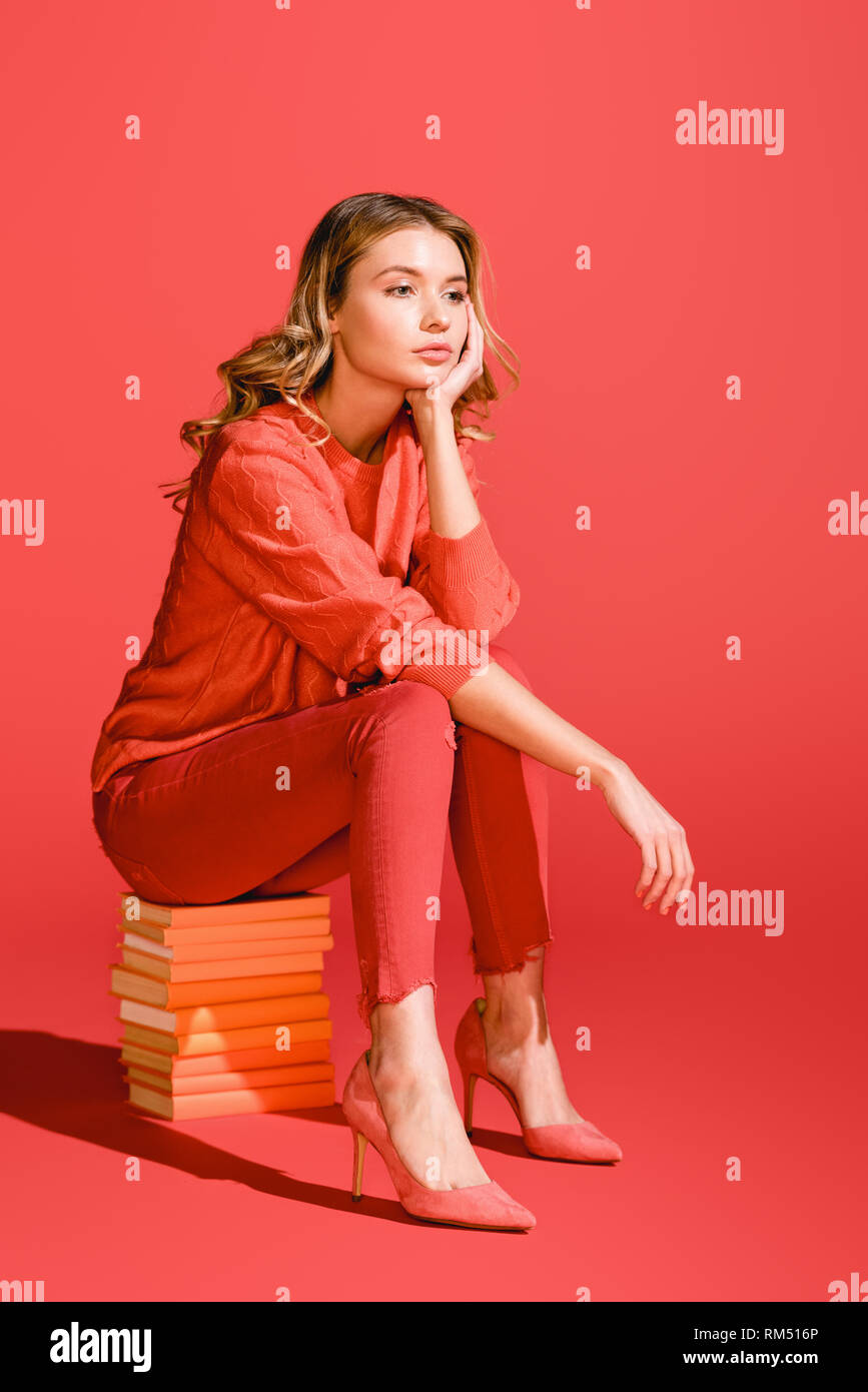 Attraktive modische Frau sitzt auf der Bücher. Pantone-Farbe des Jahres 2019 Konzept Stockfoto