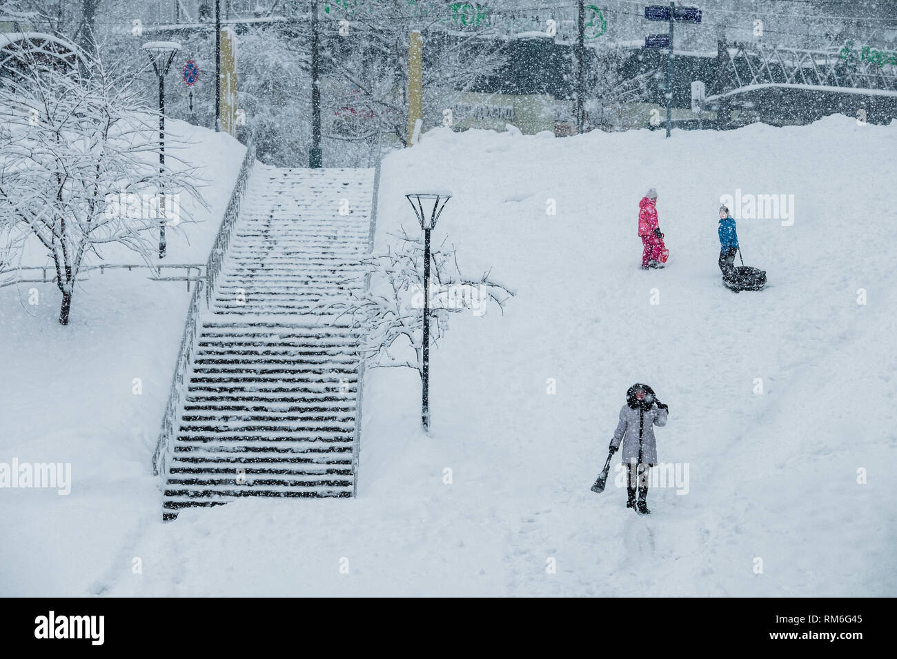 Moskau, Russland - 13. FEBRUAR 2019: Junge und Mädchen Snow Tubing ein Schneefall. Stockfoto