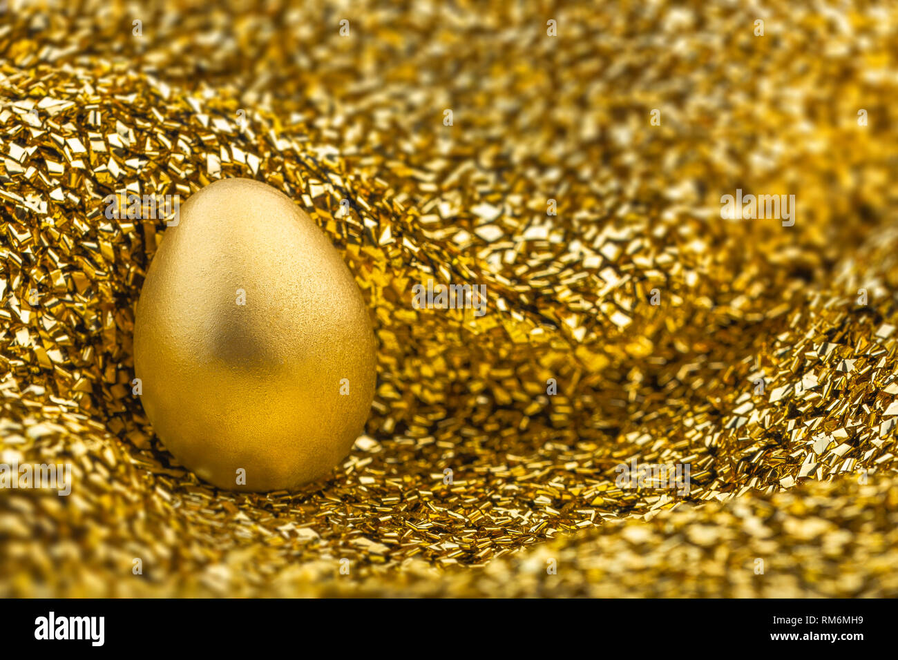 Bild von glänzenden goldenen Ei auf goldenen Stoff Stockfoto
