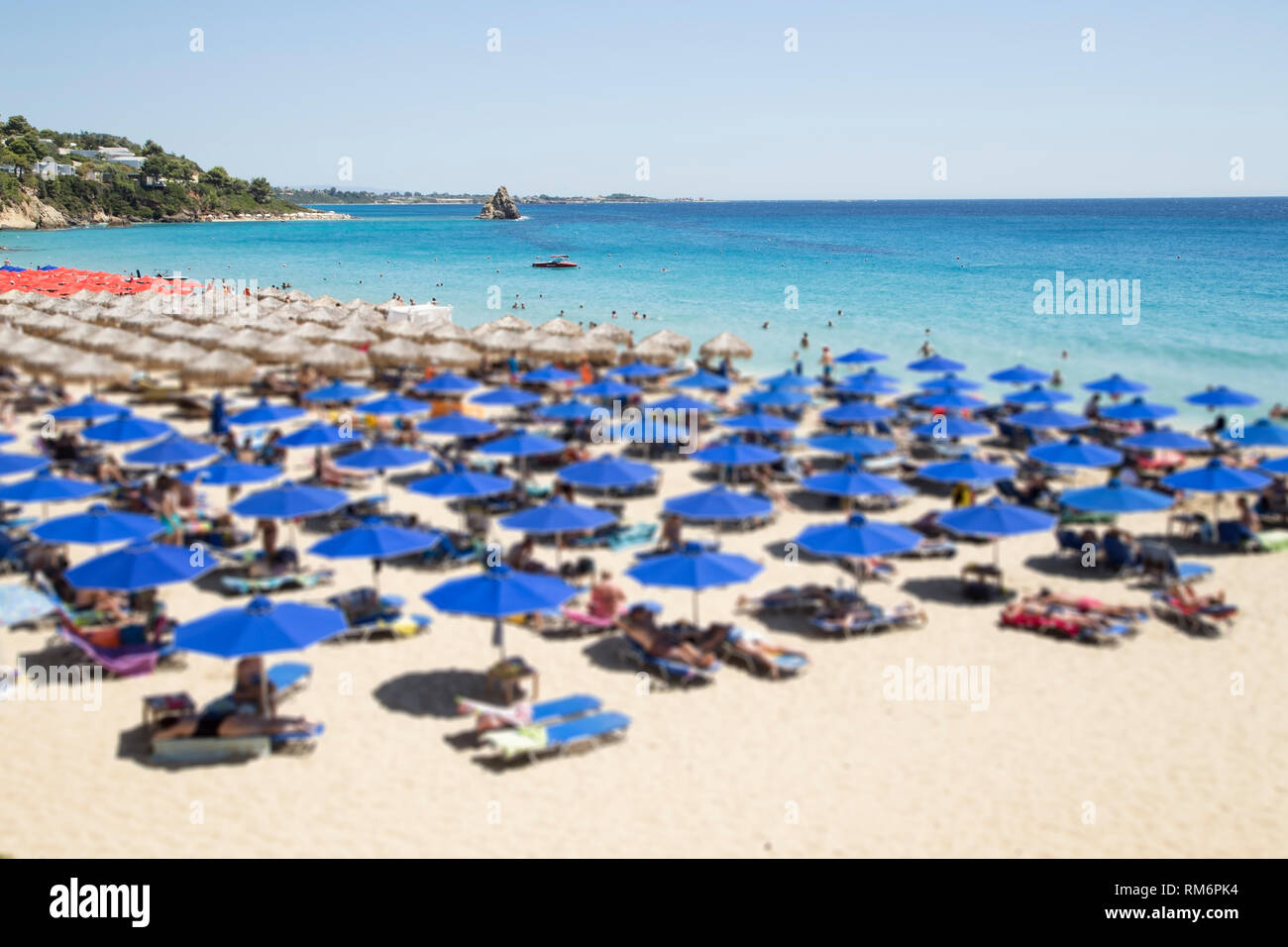 Ein Strand mit der Blauen Regenschirme - unscharfes Bild Stockfoto