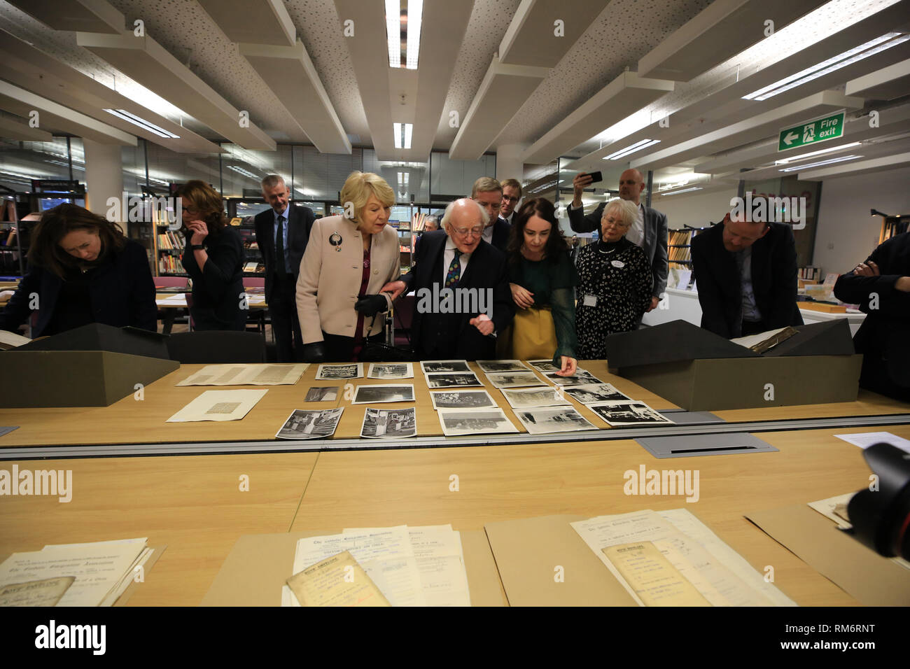 (Nach rechts) Sabina Coyne, irische Präsident Michael D Higgins und Liverpool Central Library's Erste Writer-in-Residence Catherine Morris anzeigen historische Datensätze archivieren in Irland und Emigration Verwandte Links, während der Präsident Besuch in Liverpool Central Library am dritten Tag eines offiziellen Besuchs in Großbritannien. Stockfoto