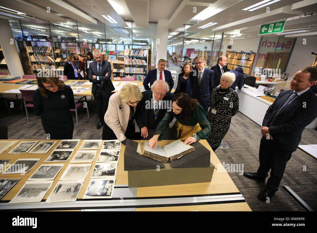 (Nach rechts) Sabina Coyne, irische Präsident Michael D Higgins und Liverpool Central Library's Erste Writer-in-Residence Catherine Morris anzeigen historische Datensätze archivieren in Irland und Emigration Verwandte Links, während der Präsident Besuch in Liverpool Central Library am dritten Tag eines offiziellen Besuchs in Großbritannien. Stockfoto
