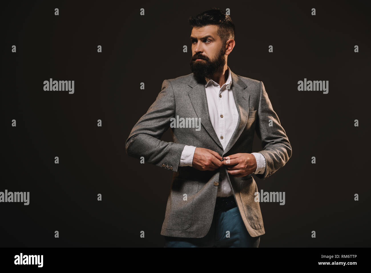 Schönen Bart Geschäftsmann in graue Jacke isoliert auf Braun Stockfoto