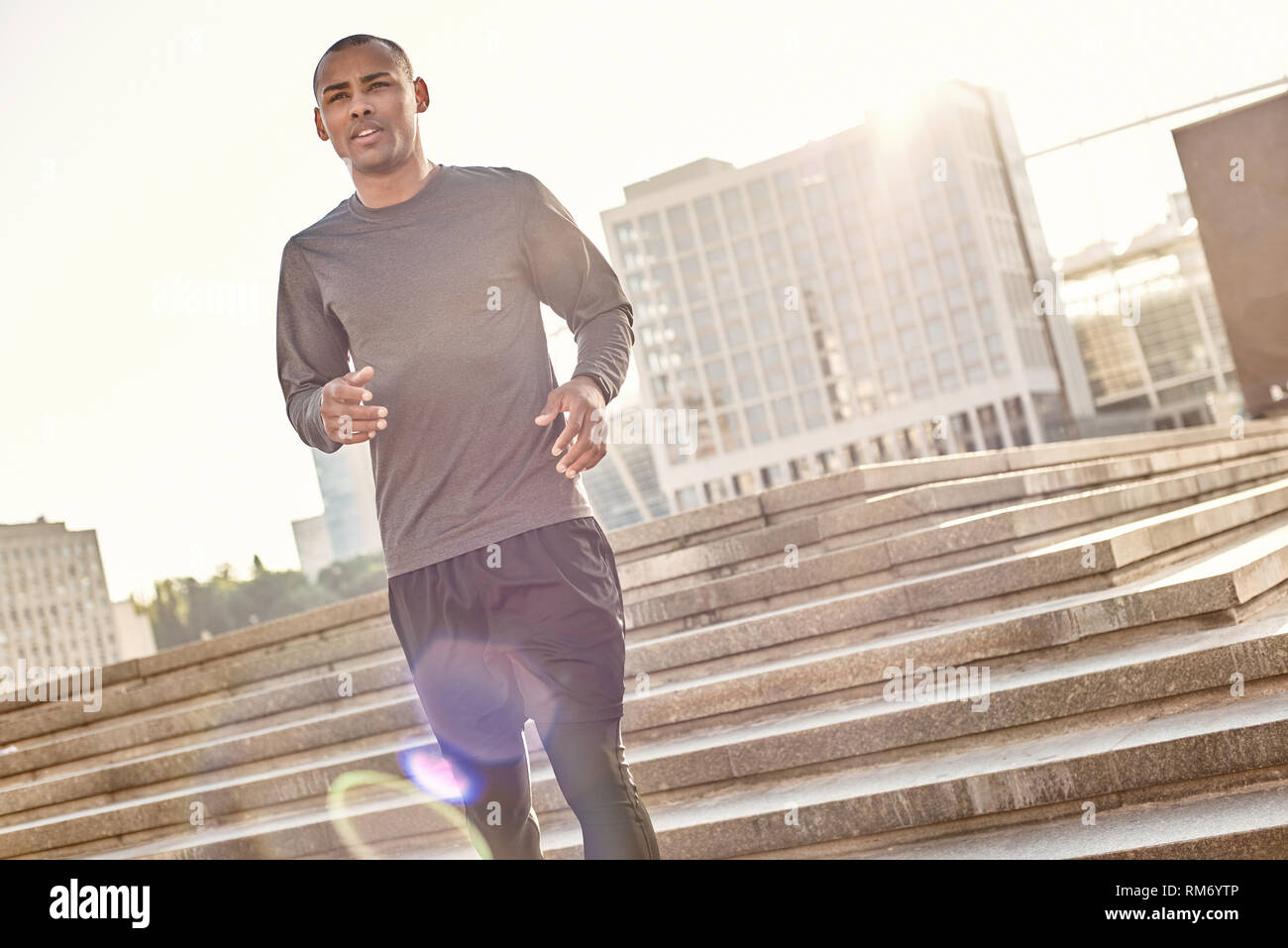 Was für ein großer Tag für Training in voller Länge Porträt der athletischen afrikanischer Mann in Sportkleidung jogging Treppen. Gesunde Lebensweise. Sport und Motivation Konzept. Urban Workout Stockfoto