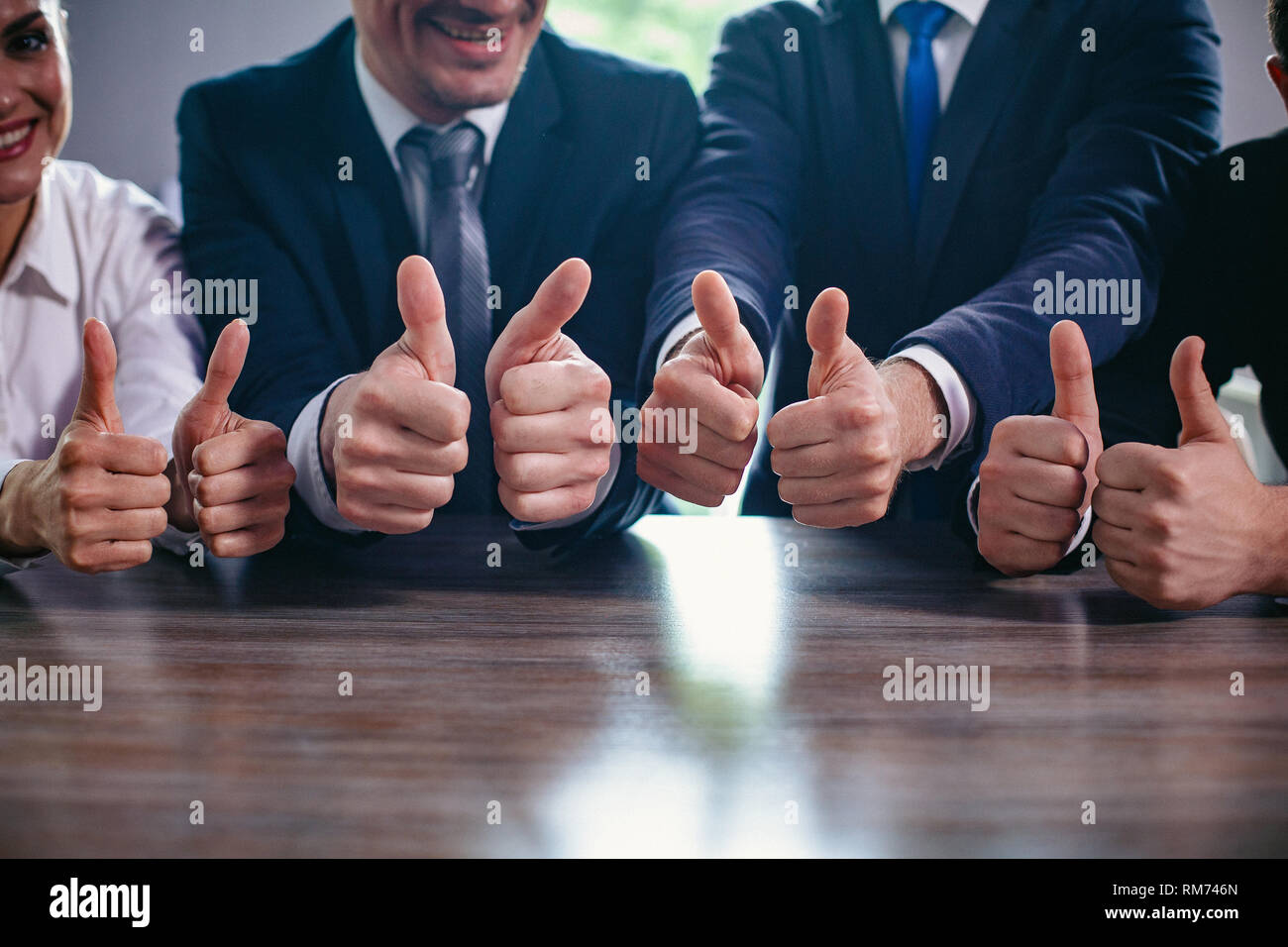 Die Unternehmer halten Daumen nach oben in einer Reihe Stockfoto