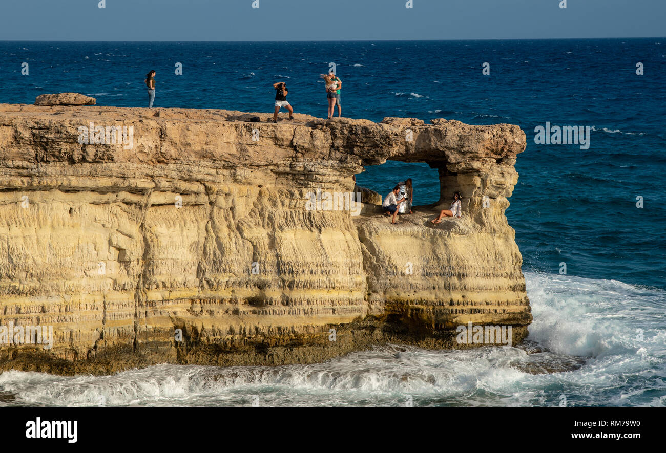 Protaras, Zypern - 30. Juli 2018: Menschen stehen und sitzen auf den Felsen, genießen Sie im kristallklaren Wasser an der berühmten Cape Greco in Protaras Bereich Stockfoto
