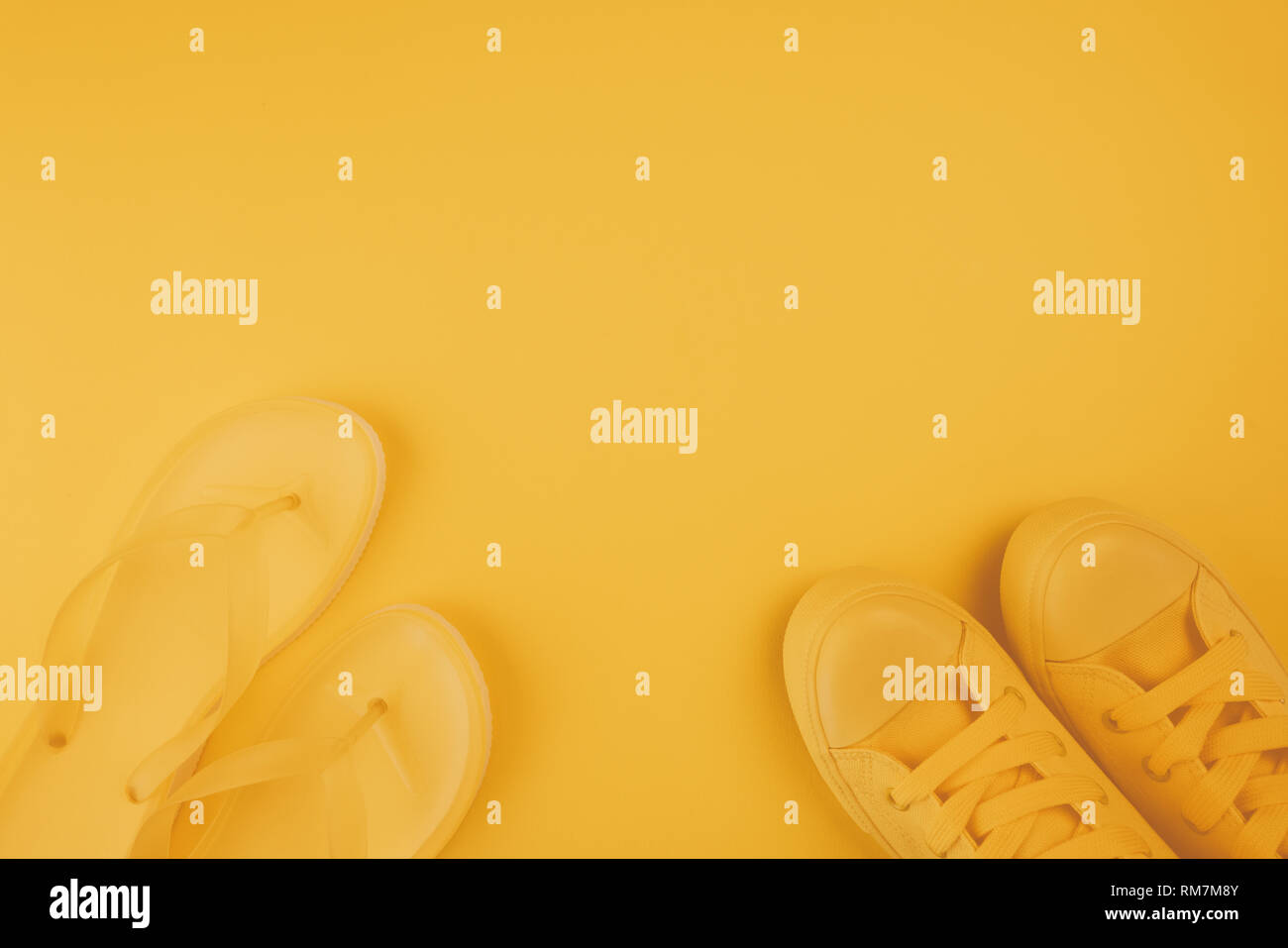 Sommer Schuhe, gelbe Turnschuhe und Flip Flops auf gleiche Farbe Hintergrund mit Kopie Raum Stockfoto