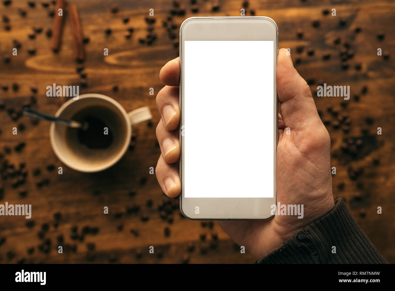 Smartphone in der Hand mock up und Kaffeetasse obere Ansicht, rustikalen Retro getonten Bild Stockfoto