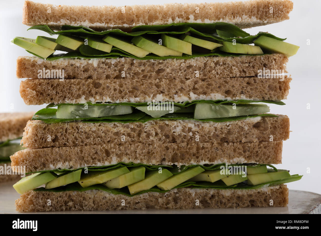 Gesund vegan Sandwiches mit grünem Gemüse und Grüns. Avocado, Spinat und Gurke Toast auf Schneiden boardover weißen Hintergrund. Auf pflanzlicher Basis fo Stockfoto