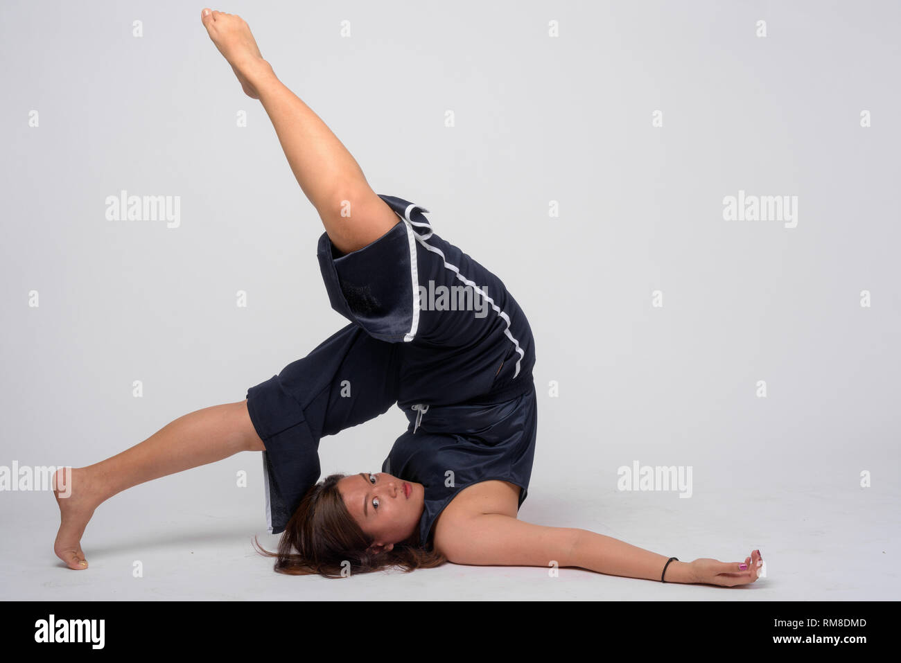 Voller Körper geschossen von jungen asiatischen Frau Stretching und Pflug yoga Pose Stockfoto