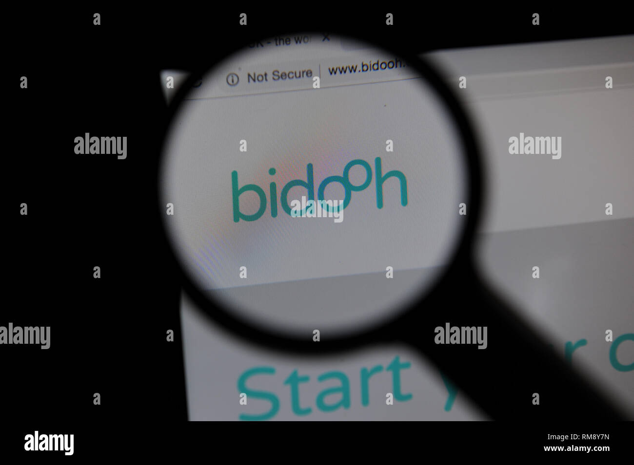 Bidooh Website durch ein Vergrößerungsglas auf einem Bildschirm gesehen Stockfoto