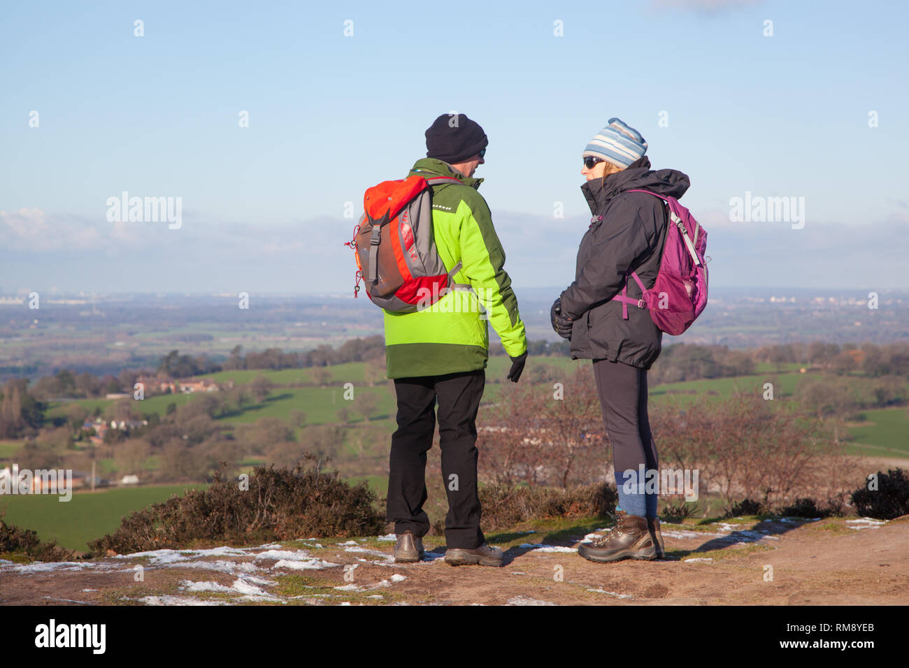 Menschen, Mann und Frau tragen Rucksäcke genießen den Blick auf die Cheshire Plain im Winter aus dem Sandstein trail auf Bickerton Hügel Cheshire Stockfoto