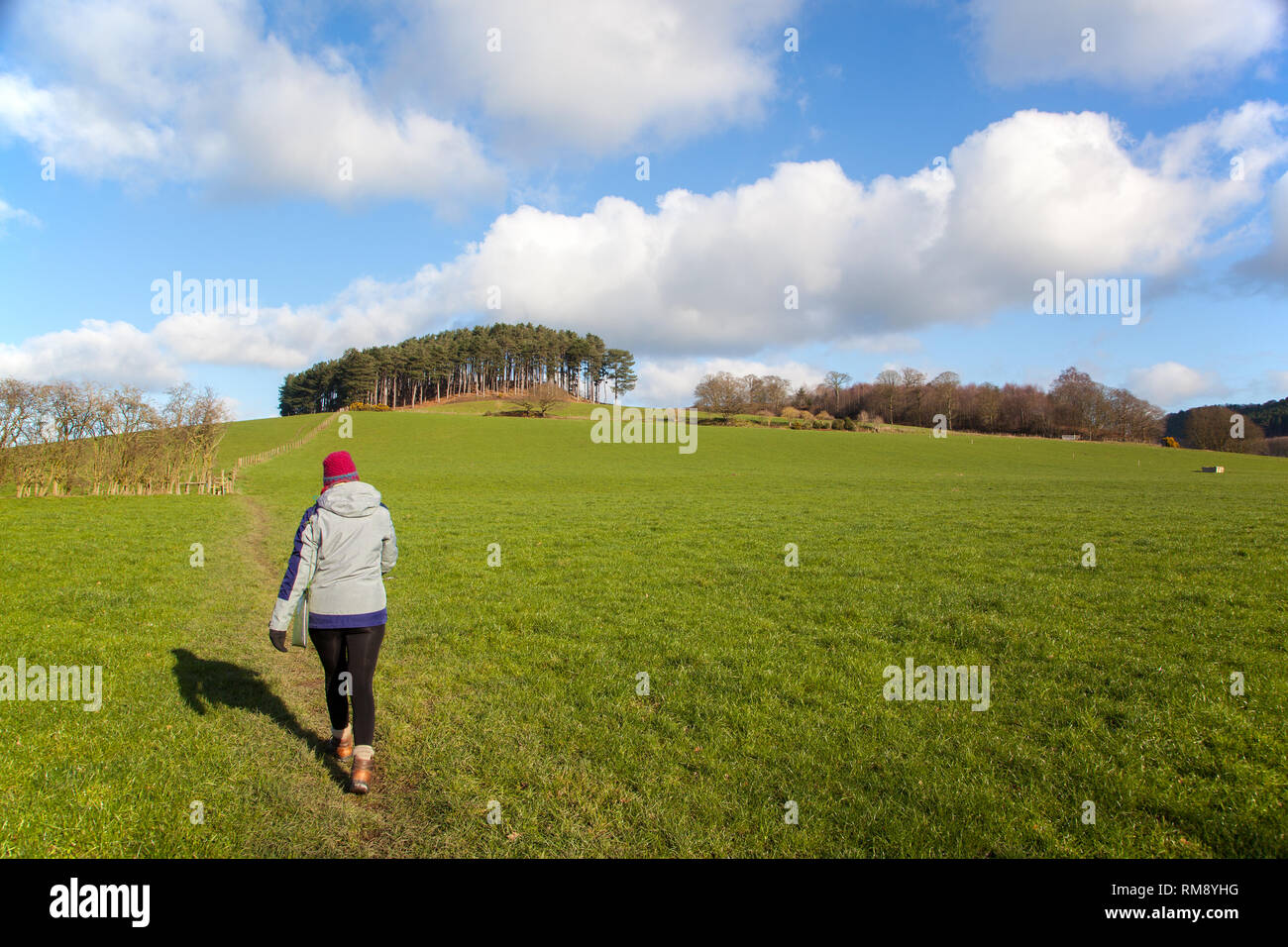 Frau Person zu Fuß in die Landschaft von Cheshire mit Hut und Outdoor Bekleidung zu Fuß in Richtung des Dorfes Harthill auf Bickerton Hügel Stockfoto
