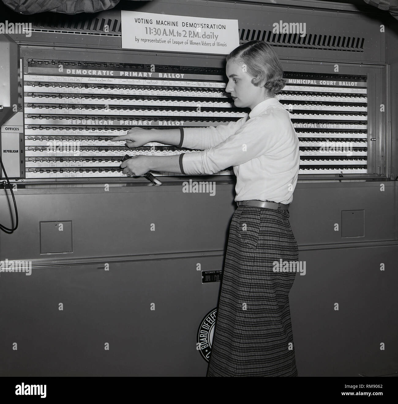 Ein Vertreter der Liga der weiblichen Wähler von Illinois zeigt ein abstimmungsgerät in Chicago, Ca. 1954. Stockfoto