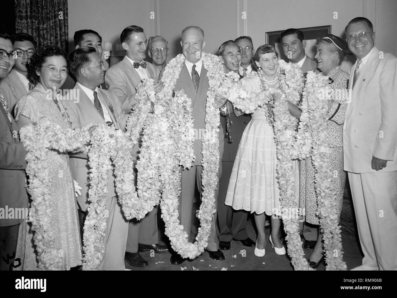 Präsident Dwight Eisenhower und die erste Dame Mamie sind in einem 150 Fuß langen Lei durch eine Delegation aus dem Gebiet von Hawaii präsentiert gewickelt, Ca. 1955. Stockfoto