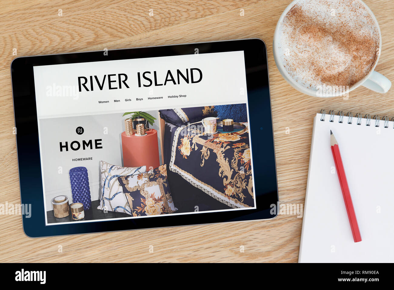 Die River Island website Funktionen auf einem iPad Tablet Gerät, das auf einem Tisch liegt neben einem Notizblock (nur redaktionelle Nutzung). Stockfoto