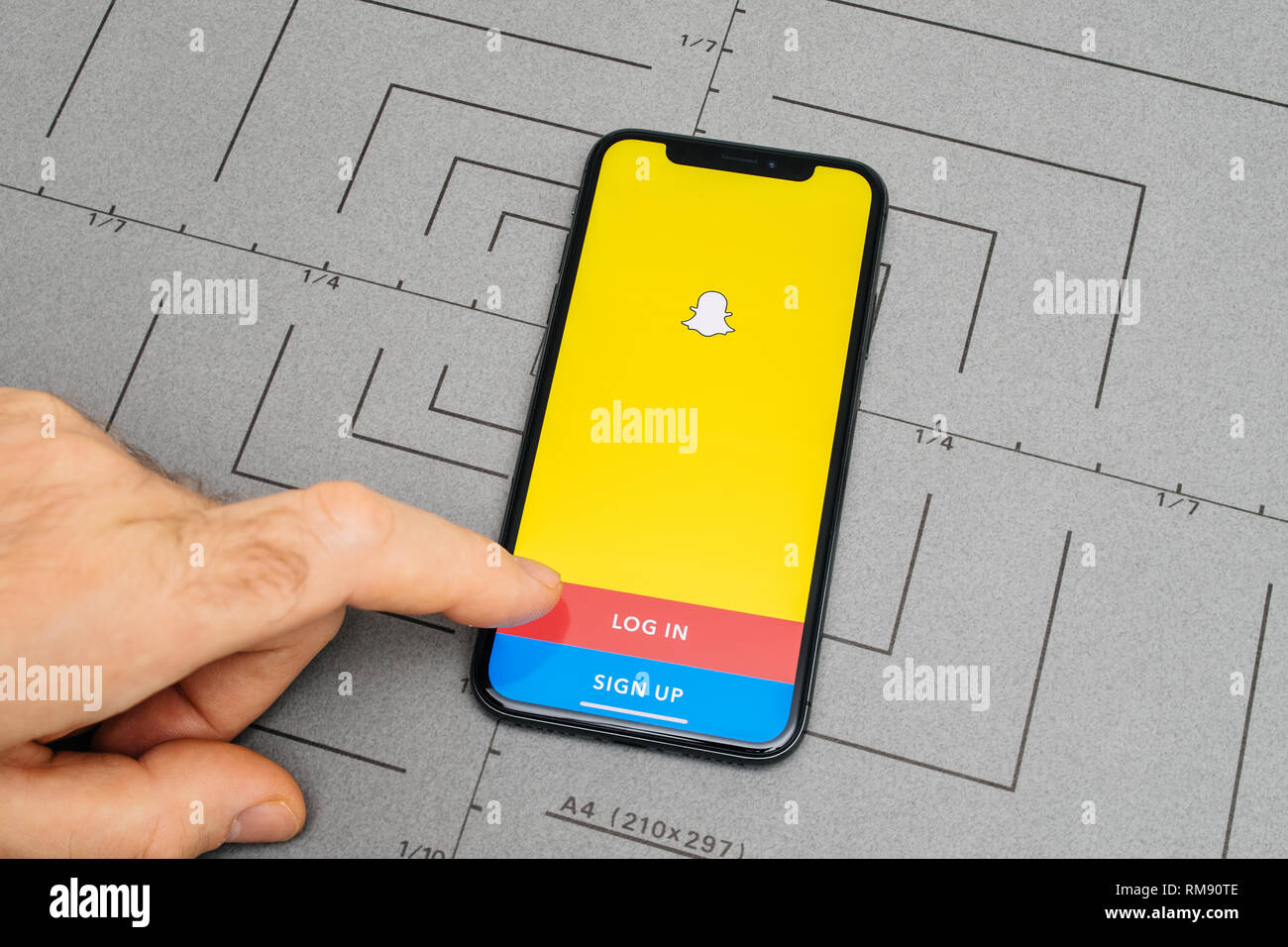 PARIS, Frankreich - Nov 9, 2017: Mann POV persönliche Perspektive auf das neueste iPhone X XS mit der Hand drücken der Taste Anmelden für Snapchat soziales Netzwerk app Stockfoto