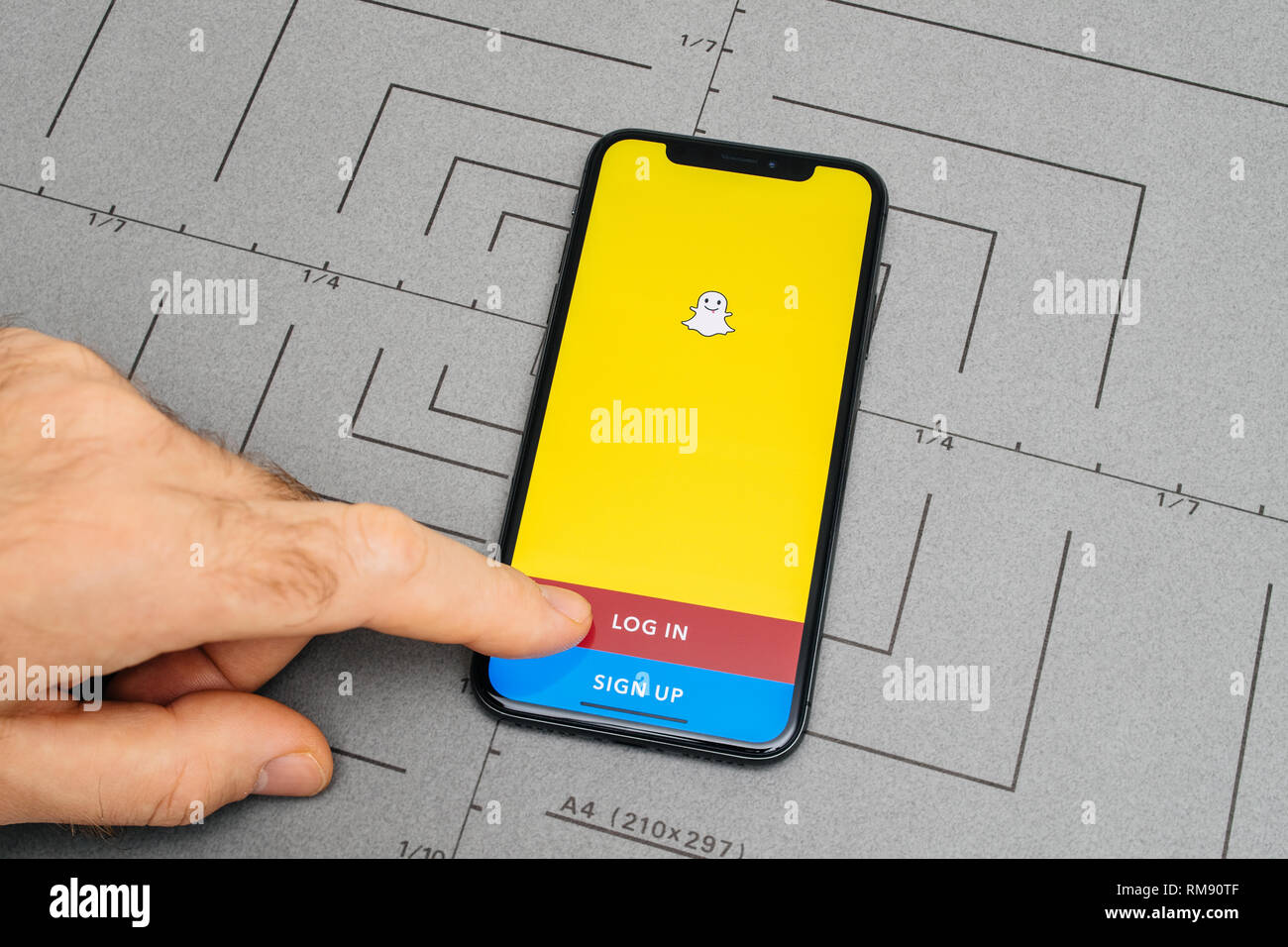 PARIS, Frankreich - Nov 9, 2017: Mann POV persönliche Perspektive auf das neueste iPhone X XS mit der Hand drücken der Taste Anmelden für Snapchat soziales Netzwerk app Stockfoto