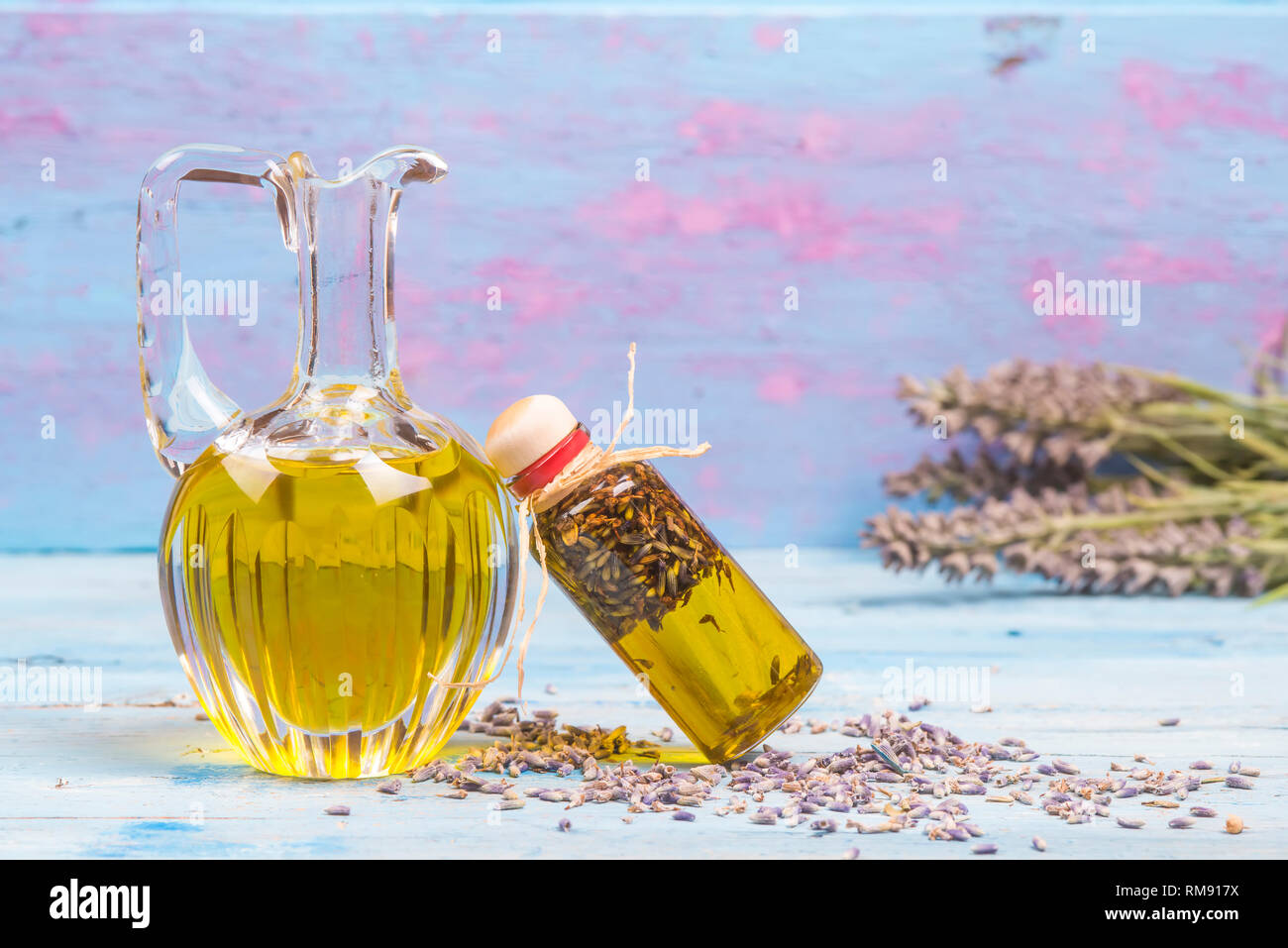 Lavendel Öl, Olivenöl aromatisiert mit Saatgut und Lavendelblüten auf hölzernen Tisch Stockfoto