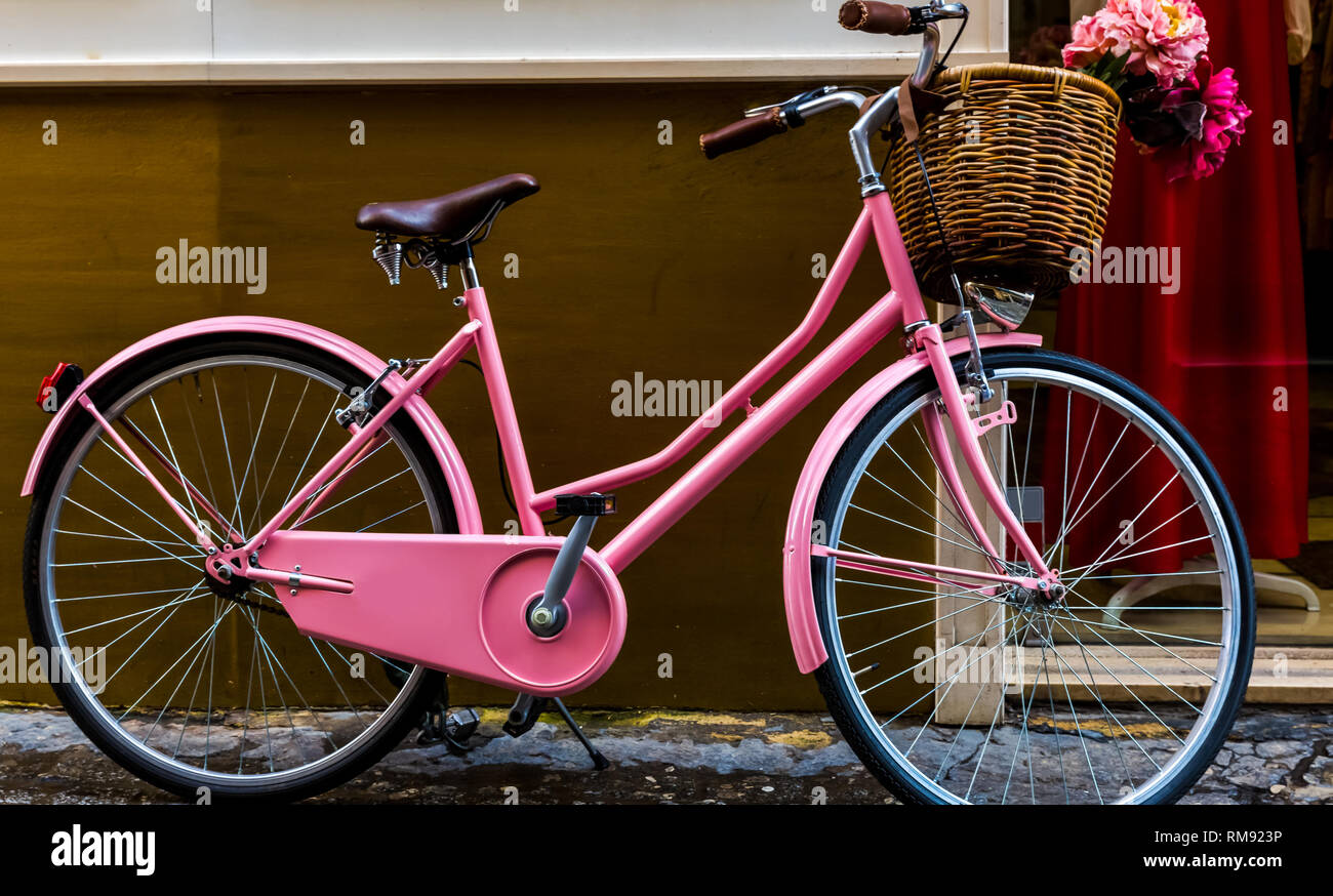 Fahrrad Rosa Damen mit einem Korb steht gegen die Wand Stockfotografie -  Alamy