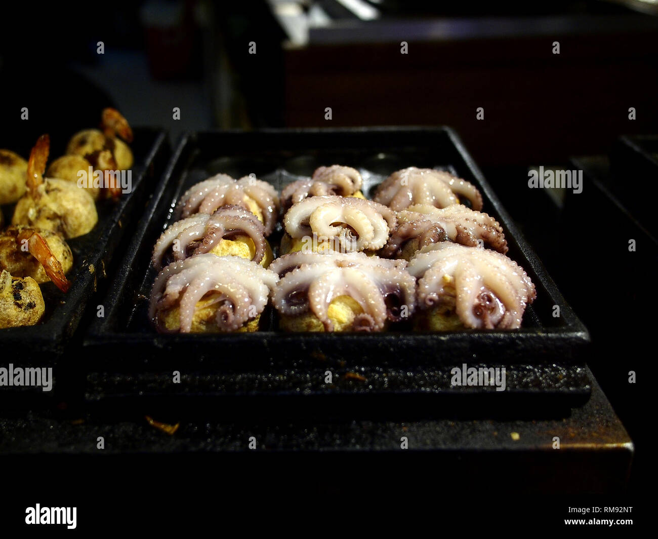 Foto der sortierten Takoyaki auf Anzeige an einem Speicher Stockfoto
