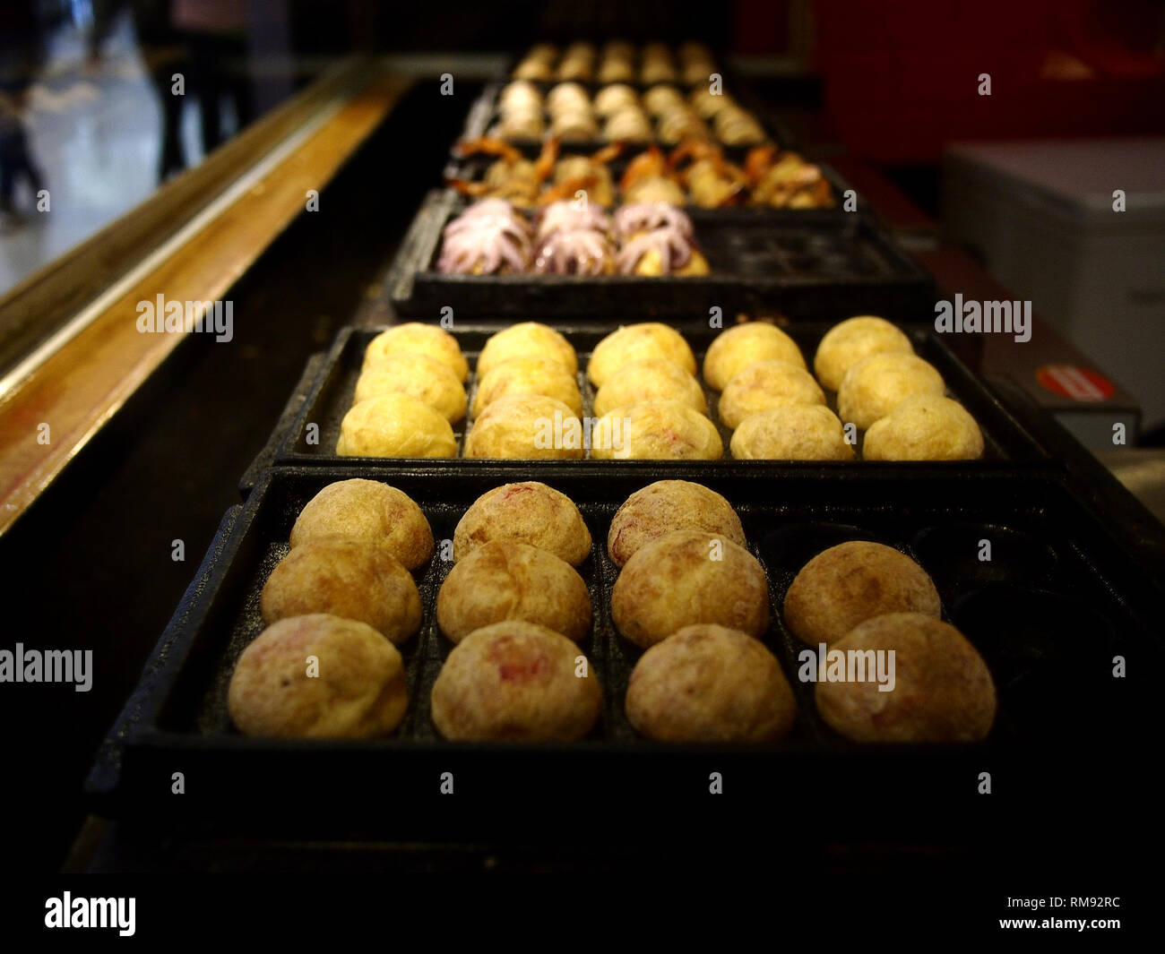 Foto der sortierten Takoyaki auf Anzeige an einem Speicher Stockfoto