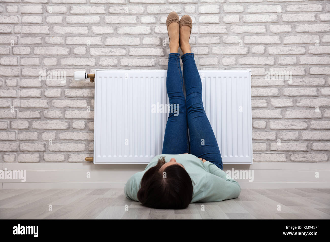 Nahaufnahme einer Frau Erwärmen ihre Füße auf weißen Kühler zu Hause Stockfoto