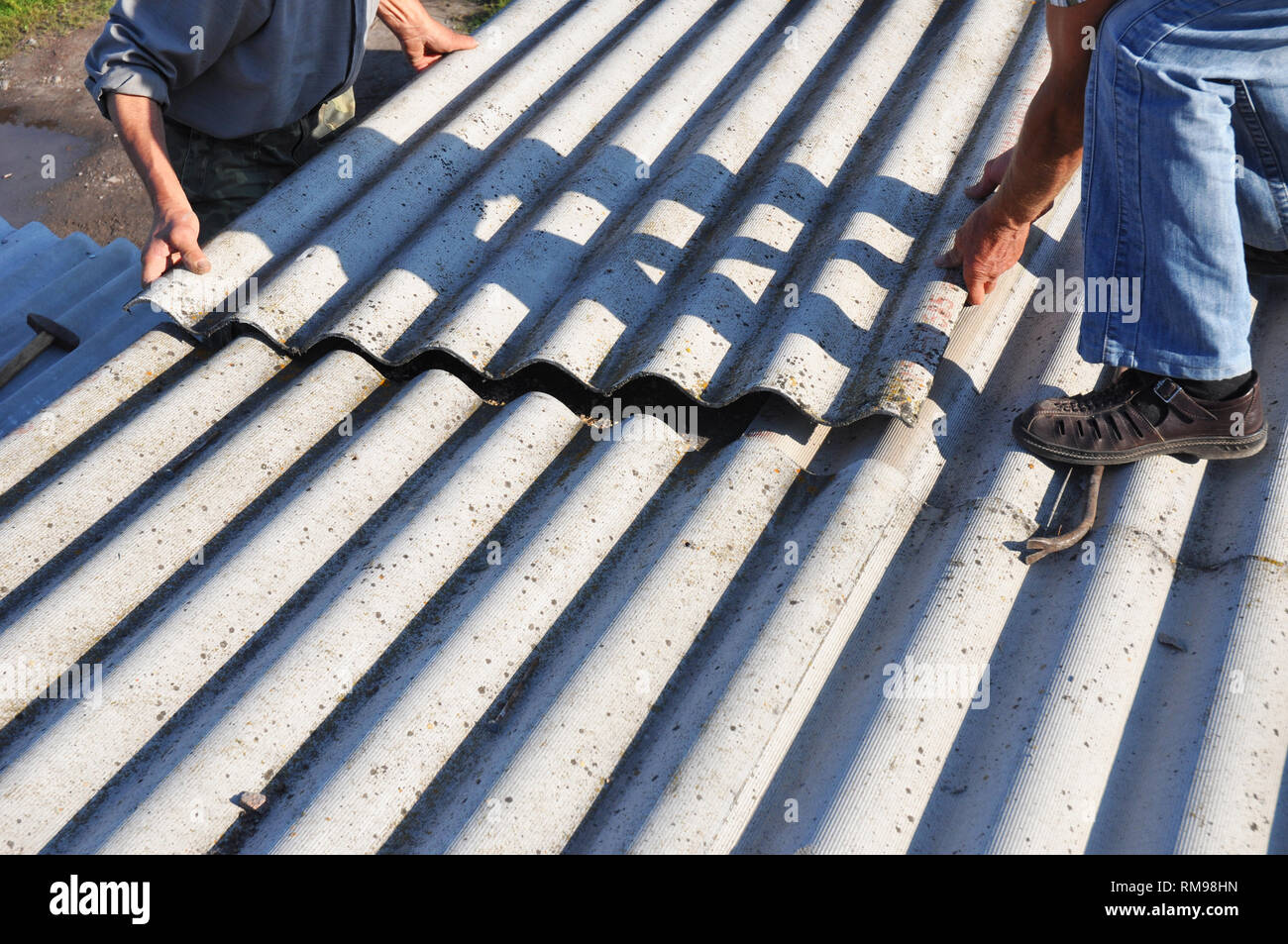 Asbest Dach- konstruktion. Dachdecker Einbau von asbesthaltigen Dachplatten. Stockfoto