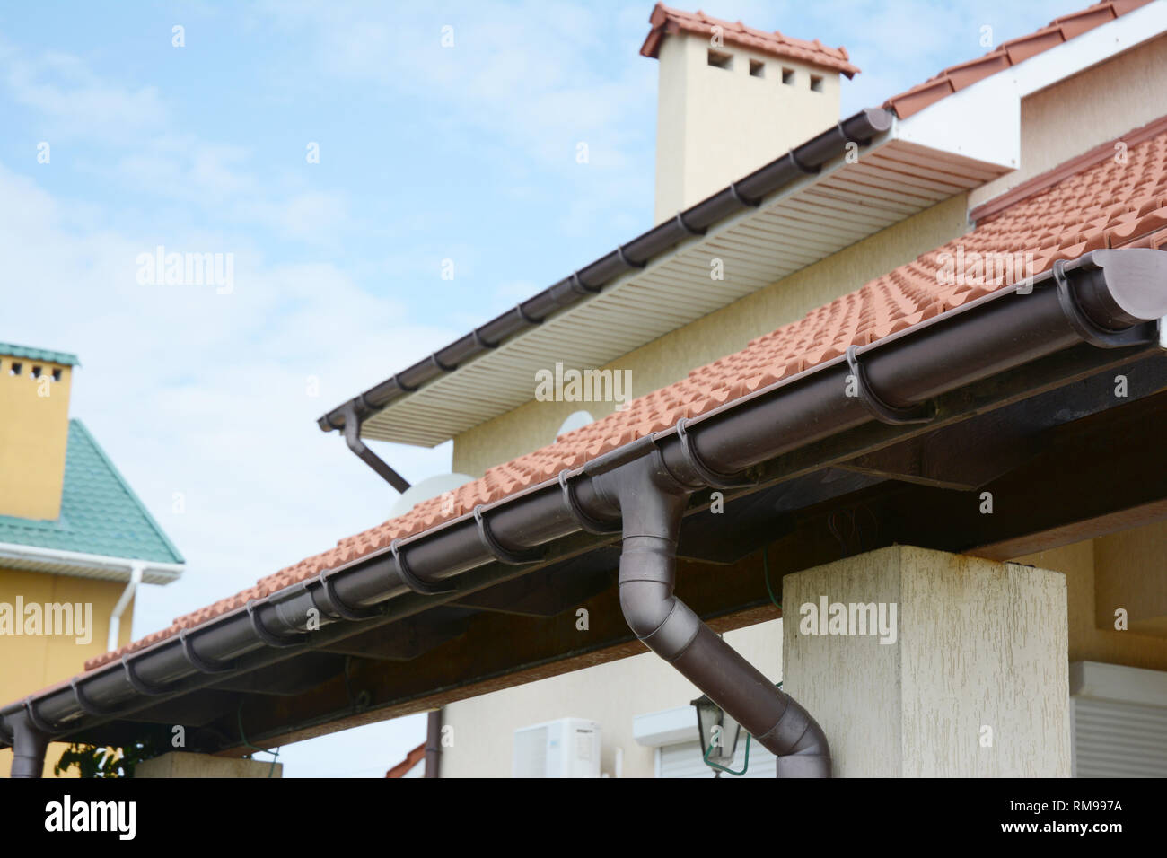 Regenrinne. Dachrinne Pipeline Systems. Haus Regenrinne mit Haltern und Downspout Leitung. Stockfoto