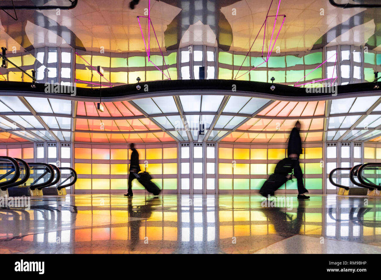 Fluggäste, Geschäftsleute zu Fuß, farbenfrohe Neonlichter Kunstinstallation von Michael Hayden, Sky's The Limit, Chicago O'Hare Airport Terminal. Stockfoto