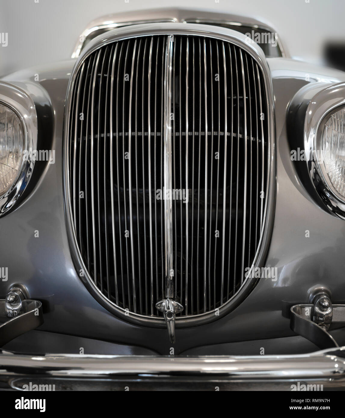 Retro Vintage silver Auto mit Chromakzenten Scheinwerfer Kühlergrill und Stoßfänger erinnert an die Kontur Gesicht räuberischen Haie in traditionellen indoor Ausstellung Stockfoto