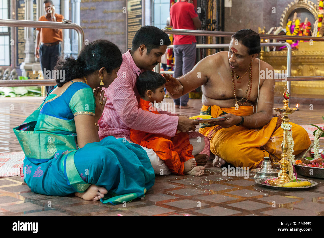 Hindu-priester Segen ein Junge, Sri Senpaga Vinyagar hinduistischen Ganesh Tempel, Joo Chiat Bezirk, Singapur. Stockfoto