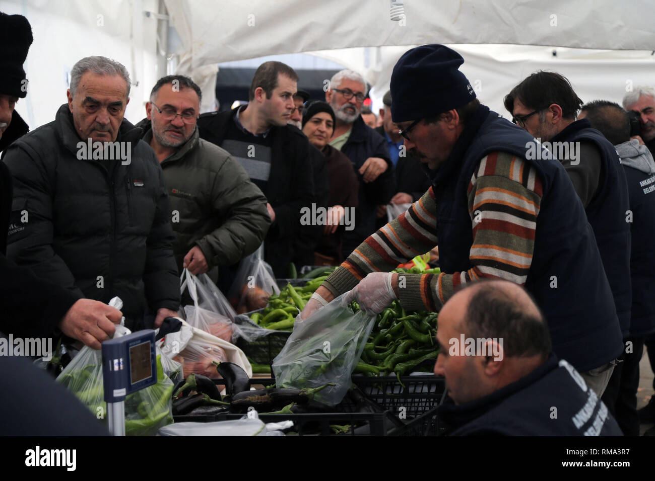 Ankara, Türkei. 13 Feb, 2019. Menschen Schlange billig Obst und Gemüse zu einem Zelt durch lokale Gemeinde in Ankara, Türkei, am 13.02.2019 zu kaufen. Am Montag, den Vertrieb zu bändigen Lebensmittelpreise in Istanbul und Ankara, Türkei's größte Städte begonnen haben, mit Menschen ein paar Kilogramm Obst und Gemüse mit der Hälfte der Marktpreise zu kaufen, in der lokalen Presse berichtet. Gehen MIT "Spotlight: Türkische Regierung Kampf gegen die steigenden Preise vor Umfragen 'Credit: Mustafa Kaya/Xinhua/Alamy leben Nachrichten Stockfoto