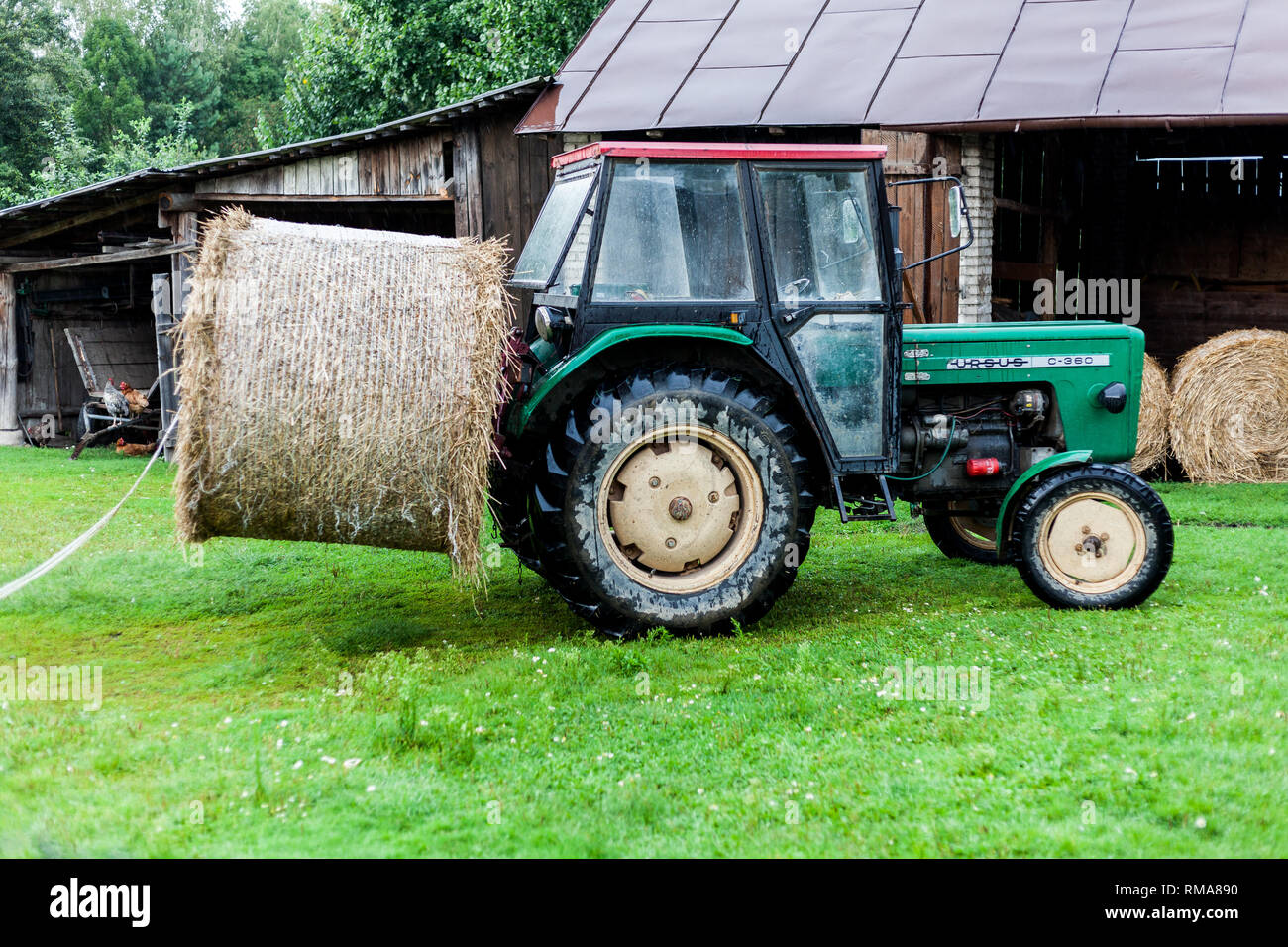 BIRMINGHAM, UK - März 2018 Mini Traktor mit Bündel von Haystack befestigt, die an der Rückseite. Öffnen Lagerhaltung für geerntete Ballen Heu. Holz- Scheune Stockfoto