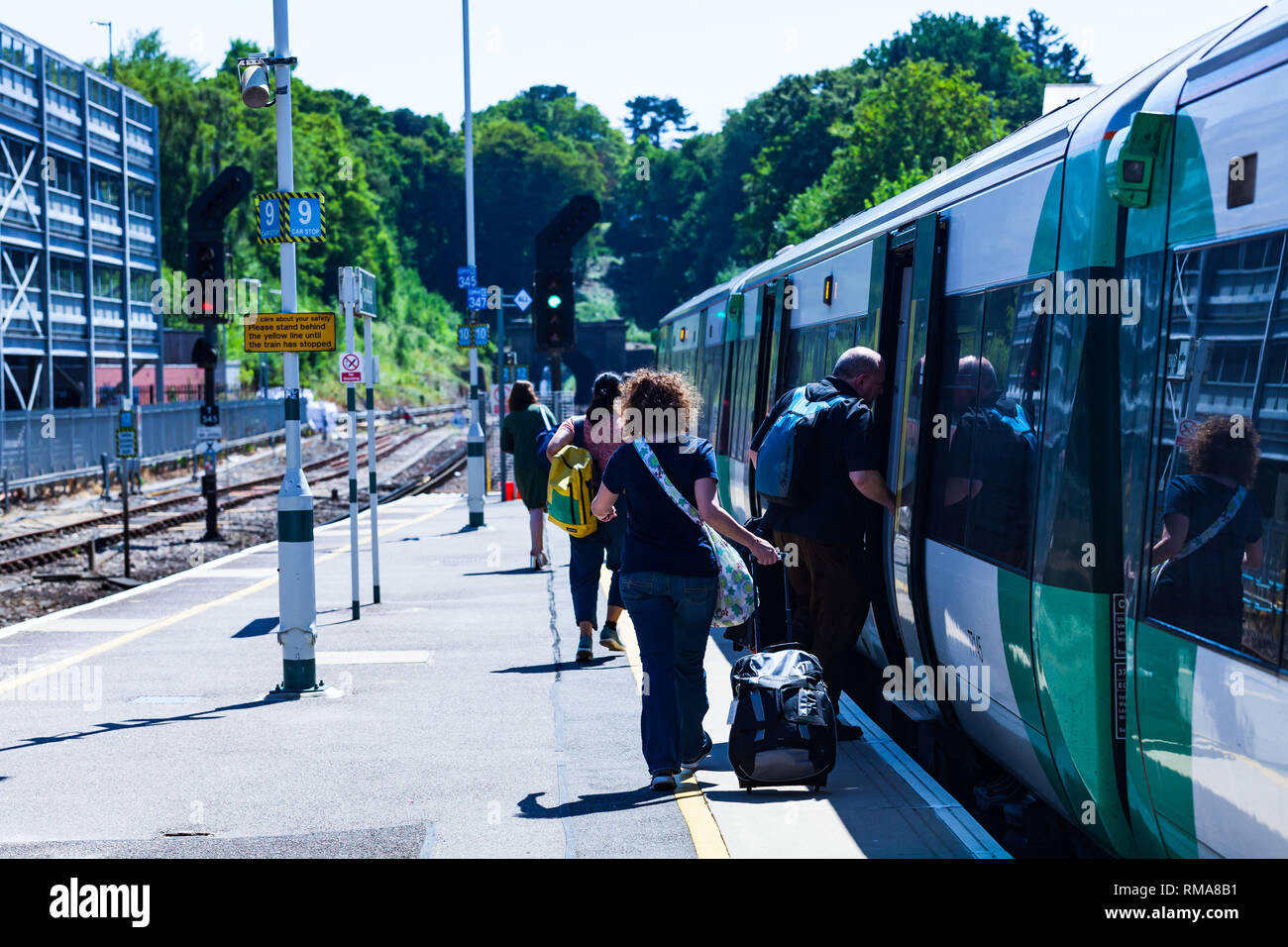 BIRMINGHAM, UK - März 2018 Pendler auf der Plattform an Bord eines Zuges. Mann über Waggon eingeben. Passagiere auf dem Weg zum Schlitten an einem sonnigen Tag Stockfoto