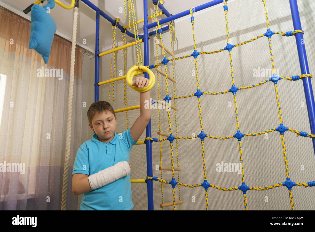 Trauriges Kind mit einem gebrochenen Arm in die häusliche Umgebung. Die Besetzung auf der Hand eines kleinen Jungen. Stockfoto