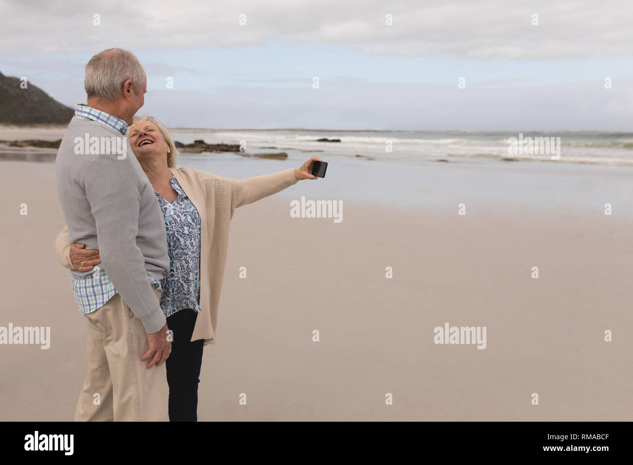Gerne älteres Paar unter selfie mit Handy am Strand Stockfoto
