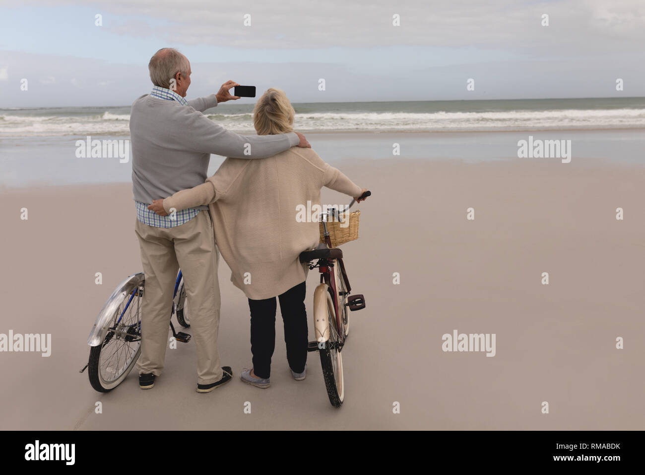 Gerne älteres Paar unter selfie mit Handy am Strand Stockfoto