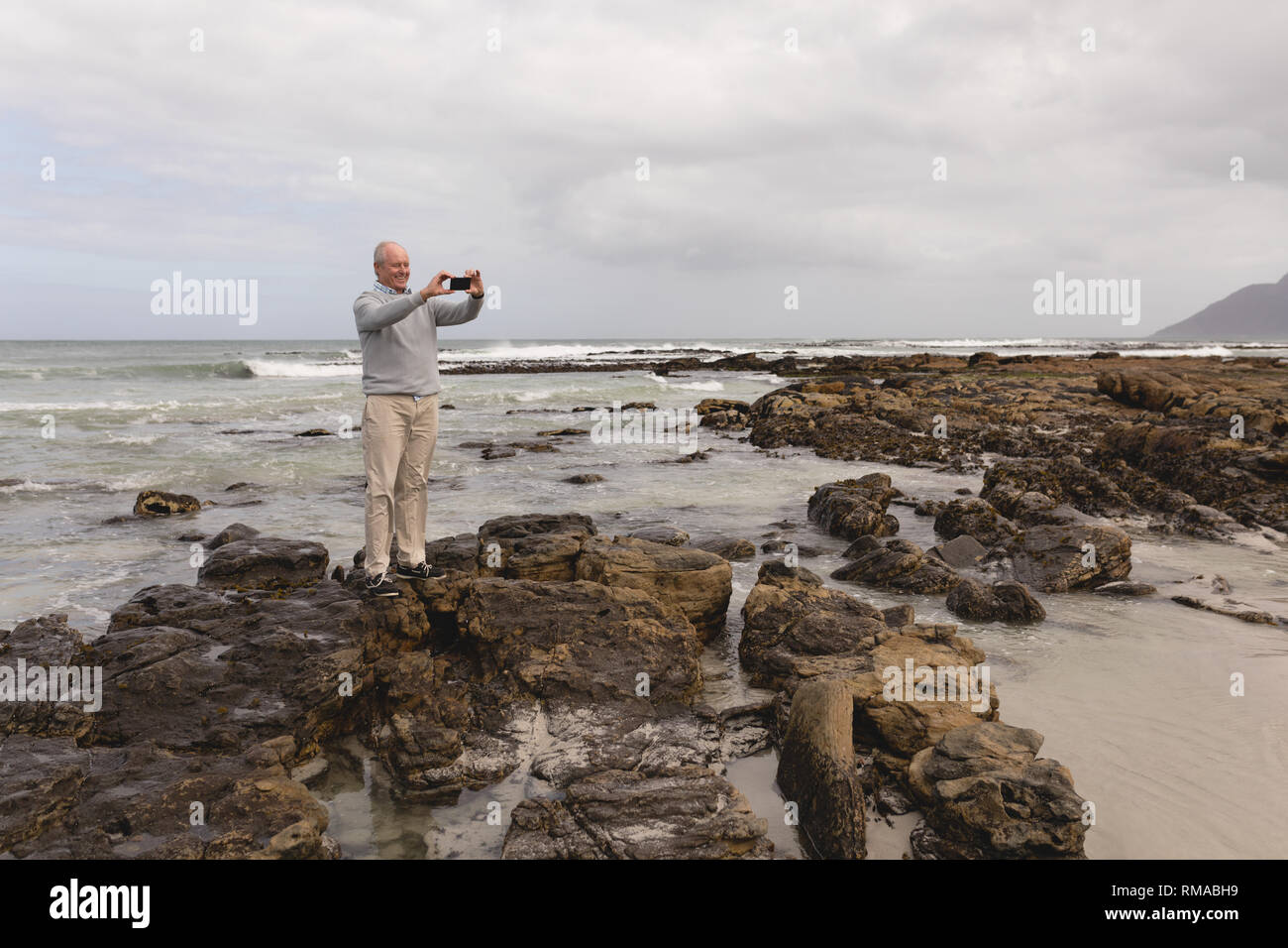 Ältere Menschen Klick auf Fotos mit dem Handy am Strand Stockfoto