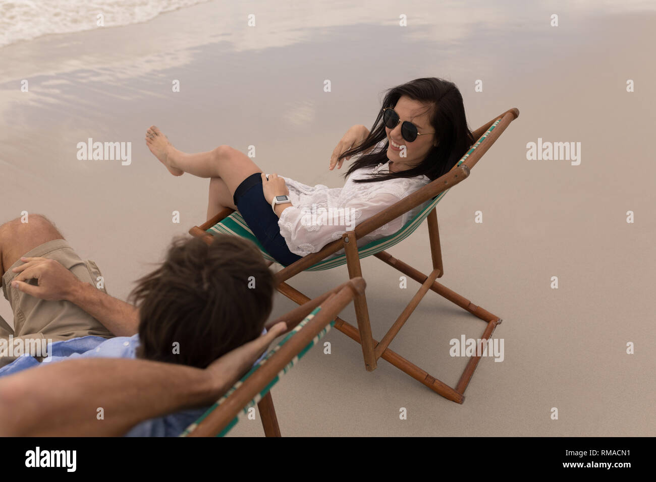 Junges Paar relaxen im Liegestuhl und Miteinander reden Stockfoto