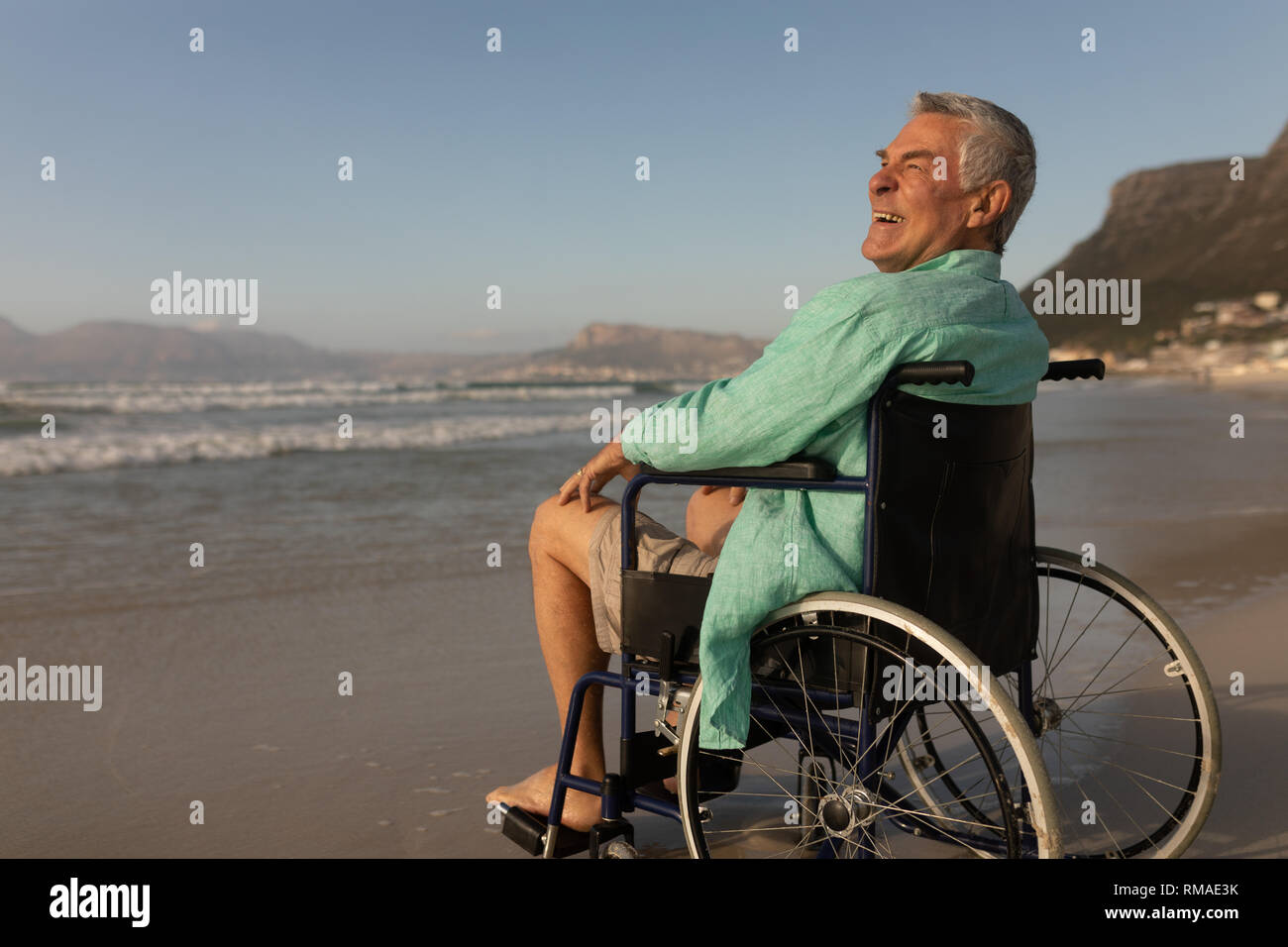 Behinderte ältere Menschen am Strand lächelnd Stockfoto