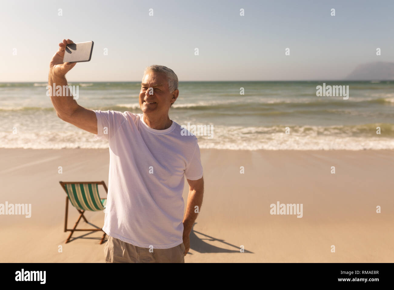 Ältere Menschen unter selfie mit Handy am Strand Stockfoto