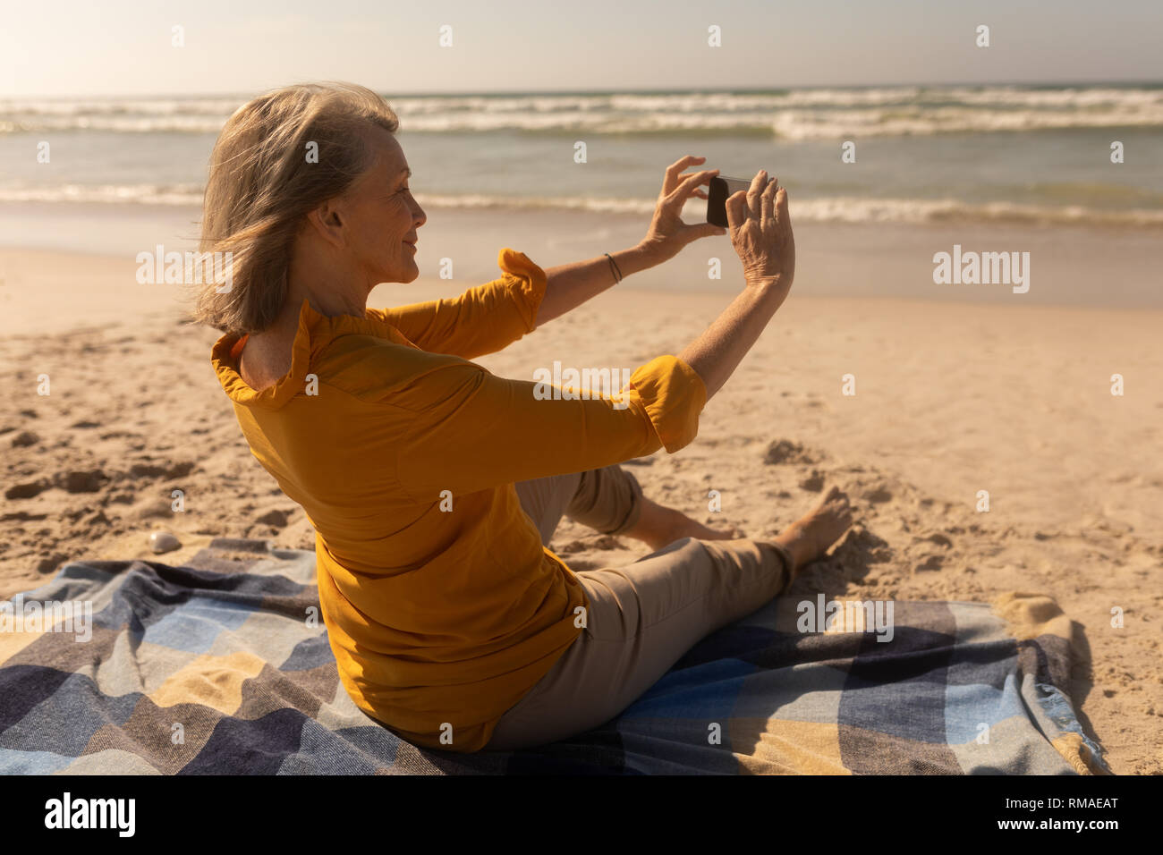 Ältere Frau unter selfie mit Handy am Strand Stockfoto