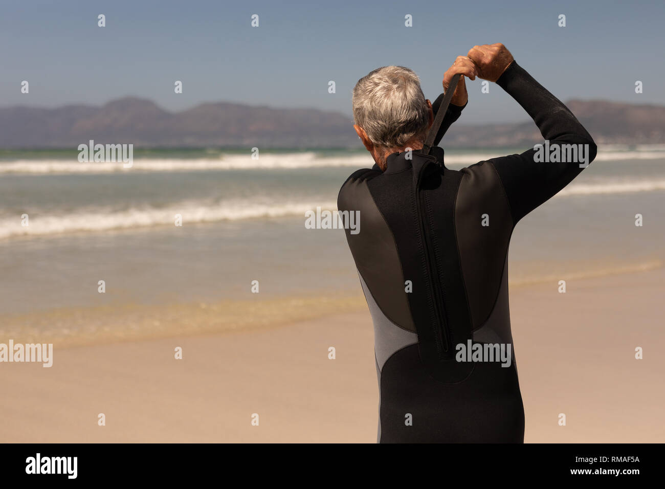Ansicht der Rückseite des älteren männlichen Surfer tragen Anzug am Strand Stockfoto