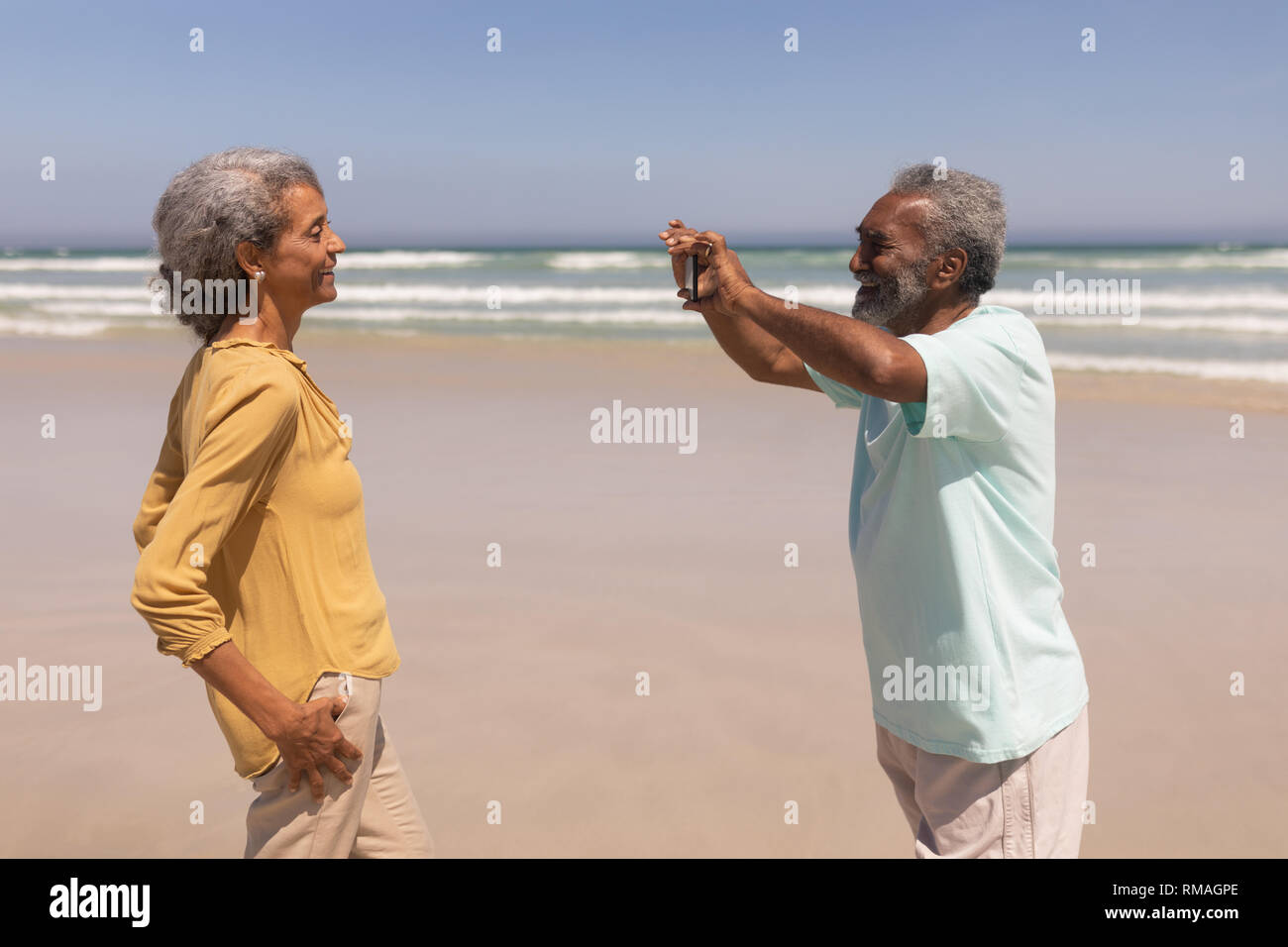 Ältere Menschen Klick auf Foto von Frau mit Handy am Strand Stockfoto