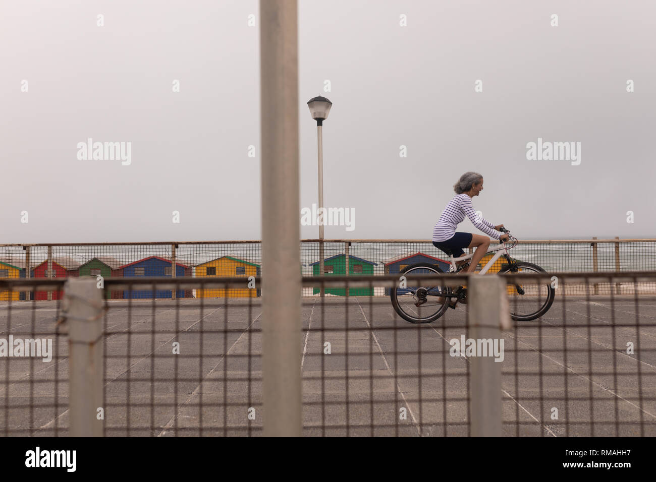 Ältere Frau Reiten Fahrrad an der Promenade Stockfoto