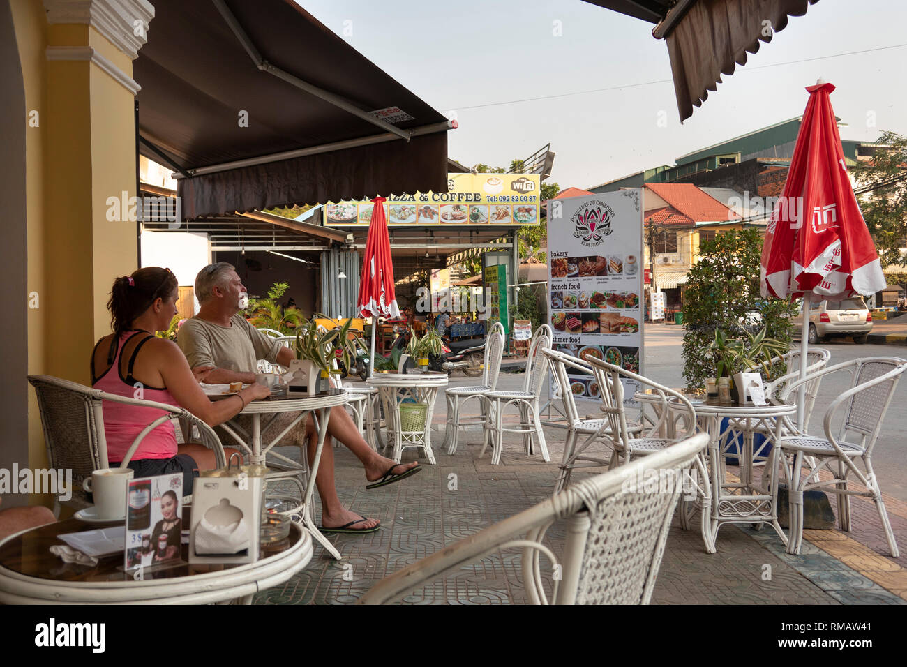 Kambodscha, Kampot Kampot Provinz, Stadt, Alten Markt, am frühen Morgen, Kunden mit Frühstück in der bürgersteig Tische draußen im französischen Stil Bäckerei Stockfoto